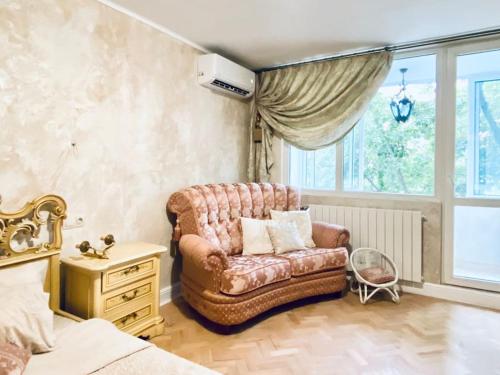 a bedroom with a couch and a bed and a window at Ellie Soe Apartment Free parking 5 min to Metro in Sofia
