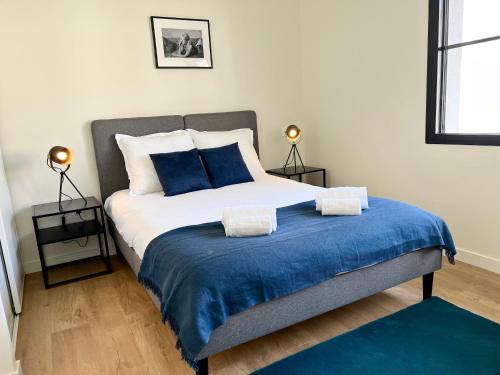 - une chambre avec un lit avec des draps bleus et deux lampes dans l'établissement Costa Del Sol - Charmant appt pour 2 avec terrasse, à Toulouse