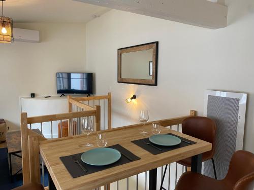 - une salle à manger avec une table en bois, des chaises et un miroir dans l'établissement Costa Del Sol - Charmant appt pour 2 avec terrasse, à Toulouse