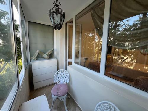 a room with a chair and a large window at Ellie Soe Apartment Free parking 5 min to Metro in Sofia