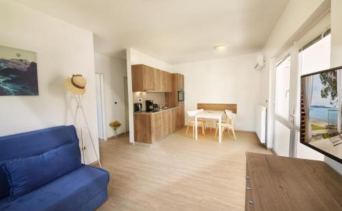 a living room with a blue couch and a table at Adria Apartments - Hotel & Resort Adria Ankaran in Ankaran