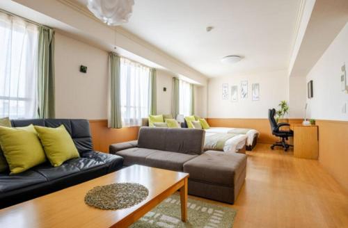 a living room with a couch and a bed at ケイアイコンホテルズ 新栄901 in Nagoya