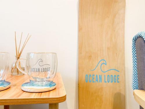 two empty glasses sitting on a wooden table at Cosy Coastal Getaway in West Wittering