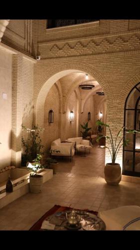 a large room with tables and couches in a building at Dar Fatima in Tozeur