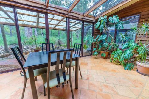 a dining room with a table and chairs in a conservatory at Bimbi Forest Eco Lodge - Denmark in Denmark