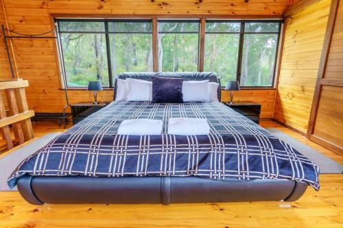 a bedroom with a large bed in a cabin at Bimbi Forest Eco Lodge - Denmark in Denmark