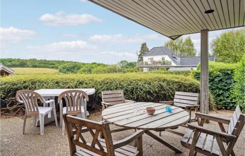 a wooden table and chairs on a patio at Lovely Home In Hesselager With Wifi in Hesselager