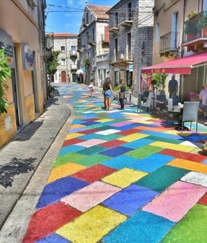 a street with a rainbow painted on the sidewalk at La terrazza del borgo in Tempio Pausania