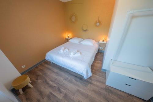 a bedroom with a bed with two towels on it at La Villa du Pont Romain in Saint-Nectaire