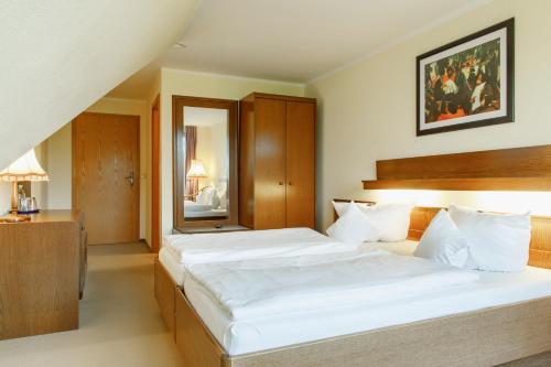 a hotel room with two beds and a mirror at Eisenberger Hof in Moritzburg