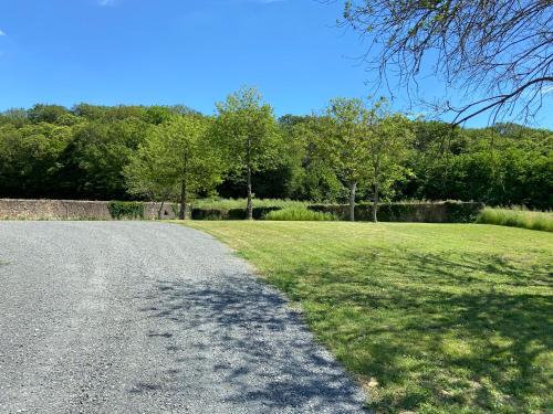 une route de gravier avec un champ d'herbe et d'arbres dans l'établissement L escapade amoureuse, à Neuville-sur-Sarthe