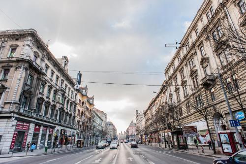 eine Stadtstraße mit Autos, die eine Straße entlang fahren in der Unterkunft All In Apartman in Budapest