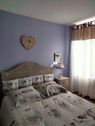 - une chambre avec un lit doté d'une horloge cardiaque sur le mur dans l'établissement Gîte à labry, à La Rochepot