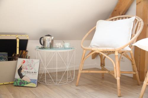 une chaise et un livre à côté d'une table dans l'établissement La Casanyères BnB - Campagne Normande - 5min Mer - Cabine de Plage, à Touffreville-sur-Eu