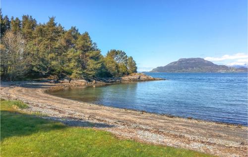a rocky shoreline with trees and a body of water at Cozy Home In Bjoa With Wifi in Utbjoa