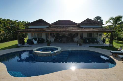 a swimming pool in front of a house at Villa Solara 6 - Luxury 6 Bedroom Villa with Pool, Golf & Lake View in Río Hato