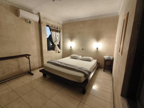 a bedroom with a bed and a window in it at Lotus 2 Guest House in Borobudur