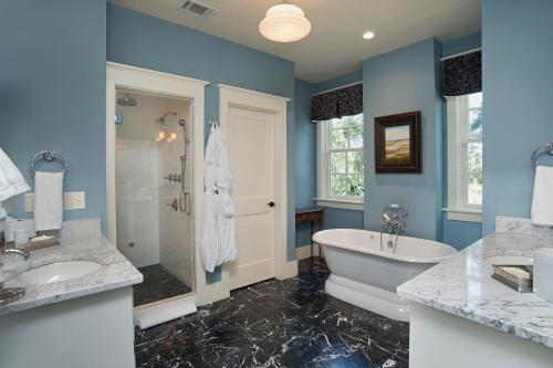 a bathroom with blue walls and a tub and a sink at 2 Bedroom Wilson Village Home 53 in Bluffton