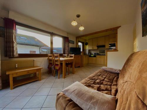 un salon avec un canapé et une table et une cuisine dans l'établissement Charmant T2 au cœur de Samoëns avec balcon, proche commerces et ski-bus - FR-1-624-44, à Samoëns