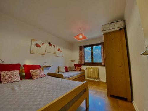 une petite chambre avec un lit et un canapé dans l'établissement Charmant T2 au cœur de Samoëns avec balcon, proche commerces et ski-bus - FR-1-624-44, à Samoëns