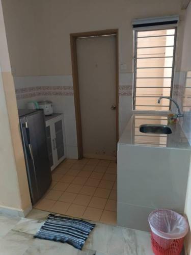 Muslim homestay Glory Beach Resort في بورت ديكسون: مطبخ مع ثلاجة وطاولة عمل