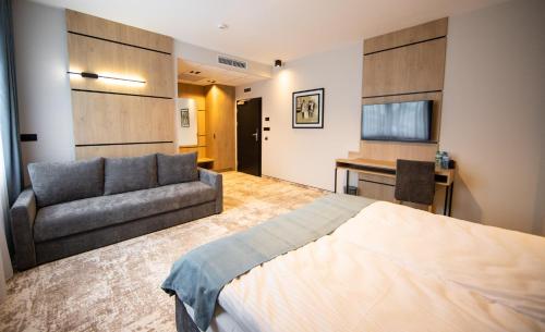 a bedroom with a bed and a couch at Sarmata in Czyżówek
