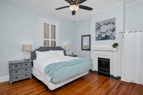 a white bedroom with a bed and a fireplace at 4BR on Henderson - Walk to USC in Columbia