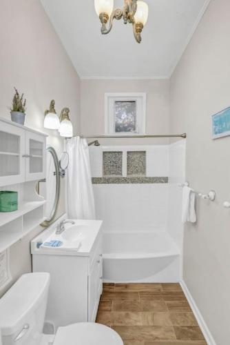 a white bathroom with a sink and a toilet at 4BR on Henderson - Walk to USC in Columbia