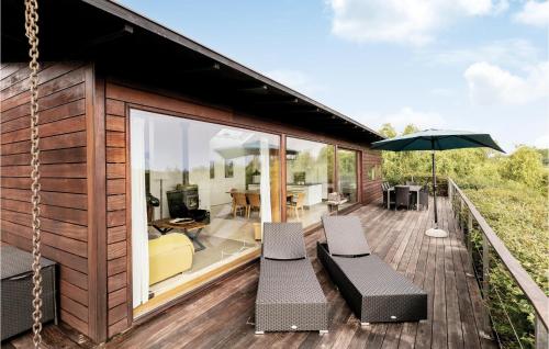 a house with a deck with chairs and an umbrella at Holiday Home Klinteløkken Allinge V in Allinge