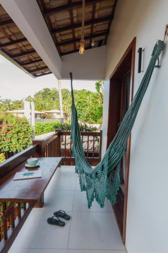 a hammock on the porch of a house at Villa Estrela Bungalow in Itacaré
