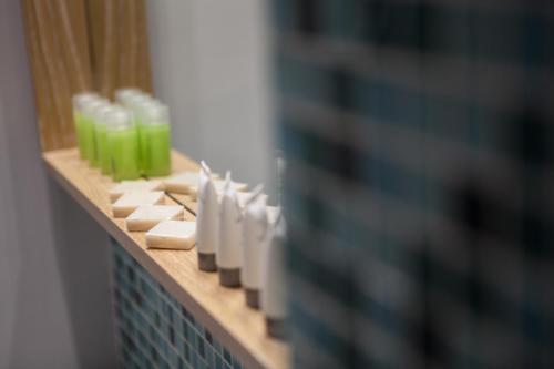 a row of soap dispensers on a shelf in a bathroom at Anemos Rooms & Apartments in Nafplio