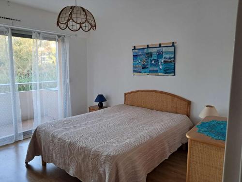 une chambre avec un lit et une grande fenêtre dans l'établissement Bel appart centre Lavandou, clim, Wi-Fi, proche plage - FR-1-308-185, au Lavandou