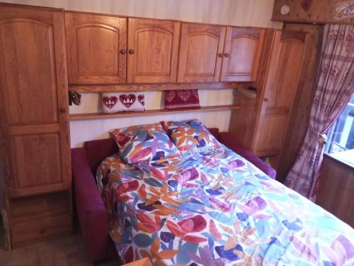 Ce lit se trouve dans un dortoir doté d'armoires en bois. dans l'établissement Studio cabine, balcon, internet et animaux admis - FR-1-629-136, à Samoëns