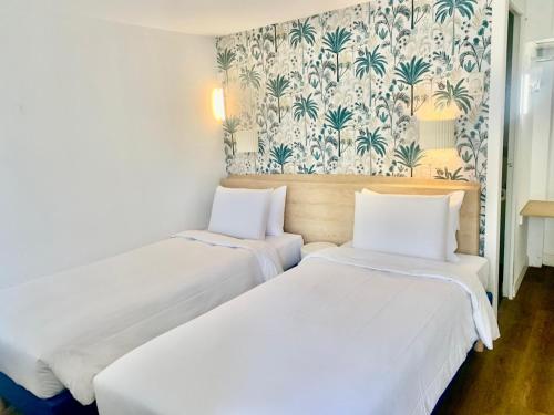 Una cama o camas en una habitación de Kyriad Cannes - Mandelieu