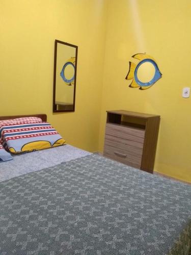 a bedroom with a bed and a dresser and a mirror at Casa da Santa in Coruripe