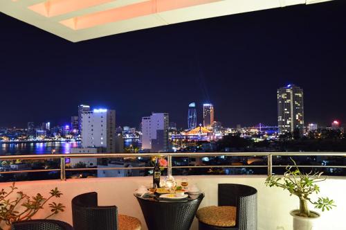 a balcony with a view of a city at night at D&C Hotel in Da Nang