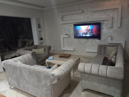 a living room with couches and a flat screen tv at gammarth la marsa in Gammarth