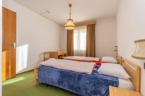 una habitación con dos camas y una mesa en Appartamento Alessandra 204, en Vigo di Fassa