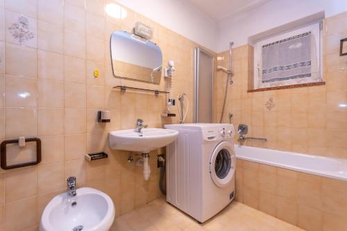 Un baño con lavadora y lavabo. en Appartamento Alessandra 204, en Vigo di Fassa