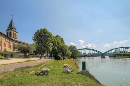 a bridge over a river with a church and a bridge at Le Francfort - Les appartements de l'olivier in Loyettes