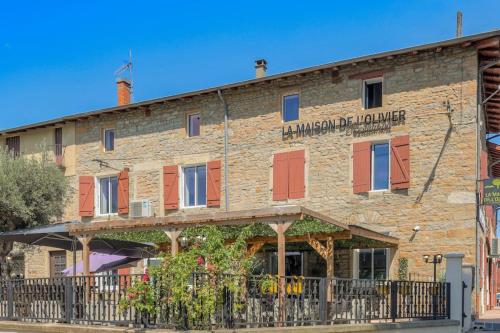 an old brick building with red shutters on it at Le Francfort - Les appartements de l'olivier in Loyettes