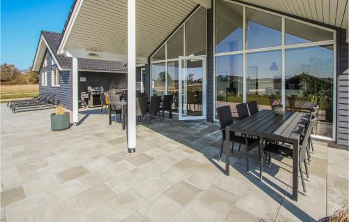 a patio with a wooden table and chairs at Stunning Home In Samsø With Sauna in Nordby