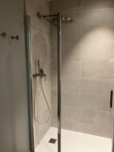une douche avec une porte vitrée dans une salle de bain dans l'établissement Goas Treiz - T3, à Trébeurden