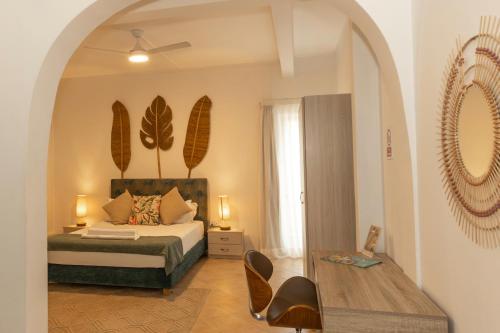 a bedroom with a bed and a table with chairs at Bleu de Toi Boutique Hotel in Grand Baie