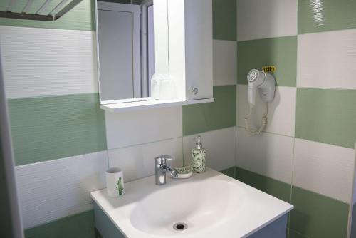 a bathroom with a sink and a mirror at Pensiunea Florentina Suceava in Suceava