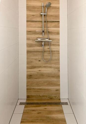 a shower in a room with a wooden floor at Wonderful Villa on water with 5 bedrooms and bathrooms in Stavoren