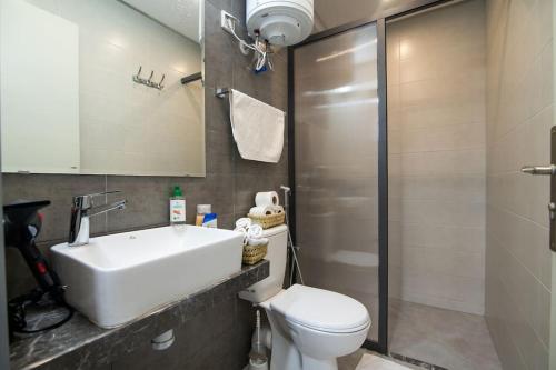 a bathroom with a sink and a toilet and a shower at Central Agadir, Modern and Convenient in Agadir