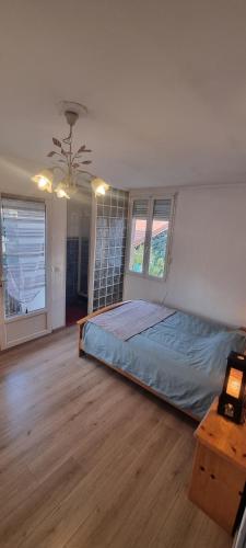 une chambre avec un lit, une table et des fenêtres dans l'établissement Maison de ville, à Villeurbanne