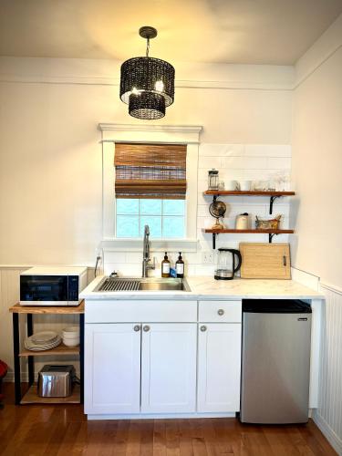 a white kitchen with a sink and a window at Swank Boutique Suites in Ashland