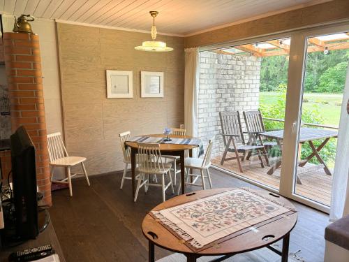 a dining room with a table and chairs on a porch at Vihula Tambi Apartment in Vihula